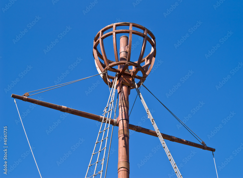 Top of mast for sailor to observe horizon over blue sky