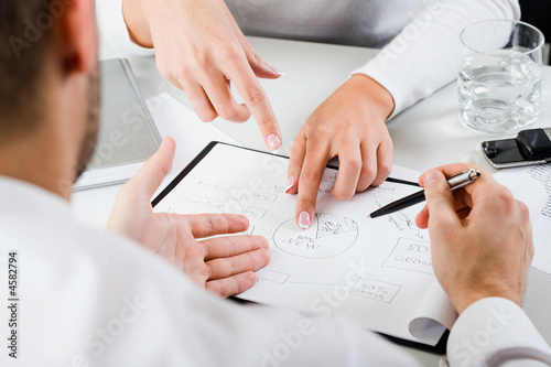 Close-up of office workers hands during discussion or brainstorming session. Suitable for business, corporate meetings, creative process, office collaboration, professional workflow visuals