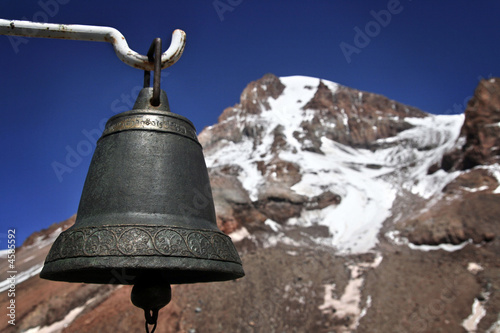 Old bell with a mountain in the background.