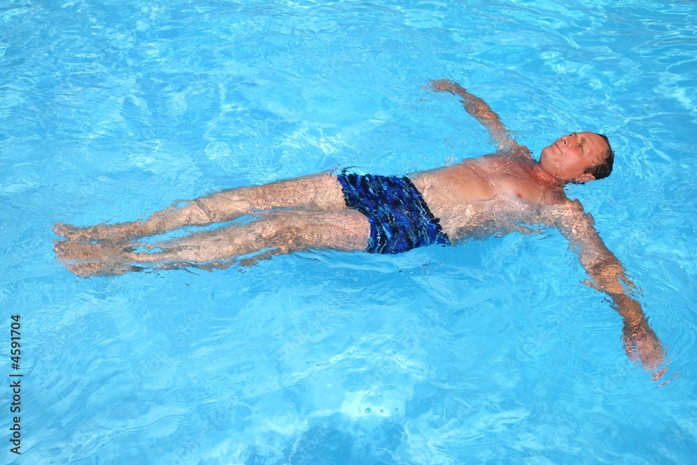 Man floating in the swimming pool 
