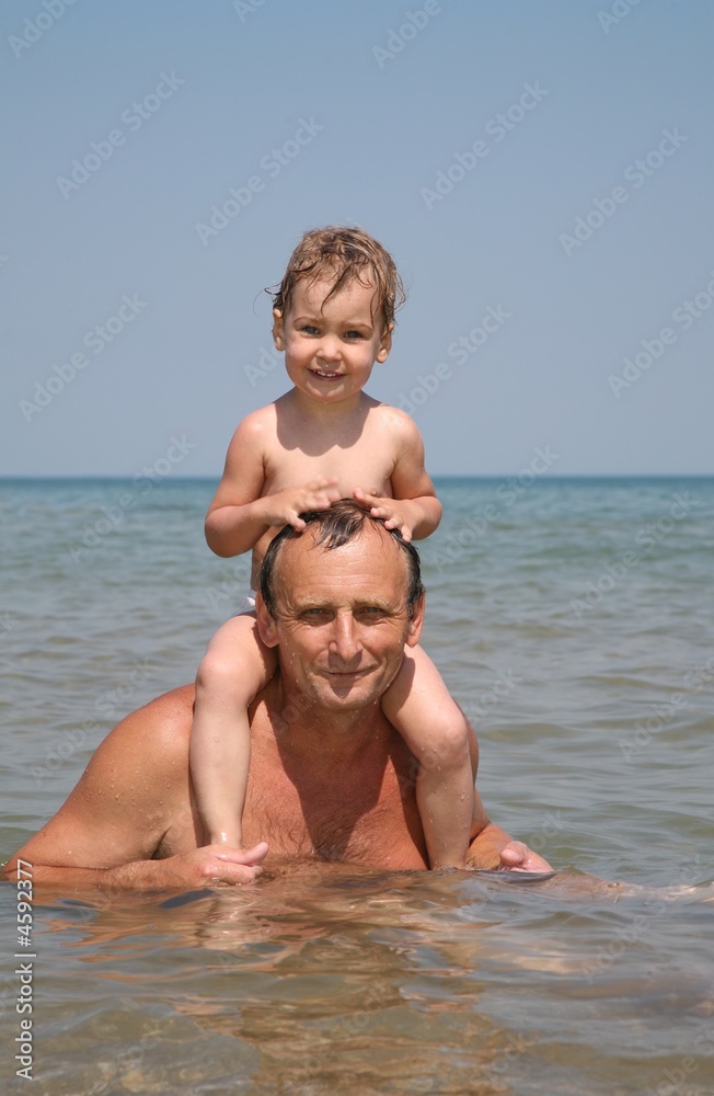 Grandfather with granddaughter on the sea