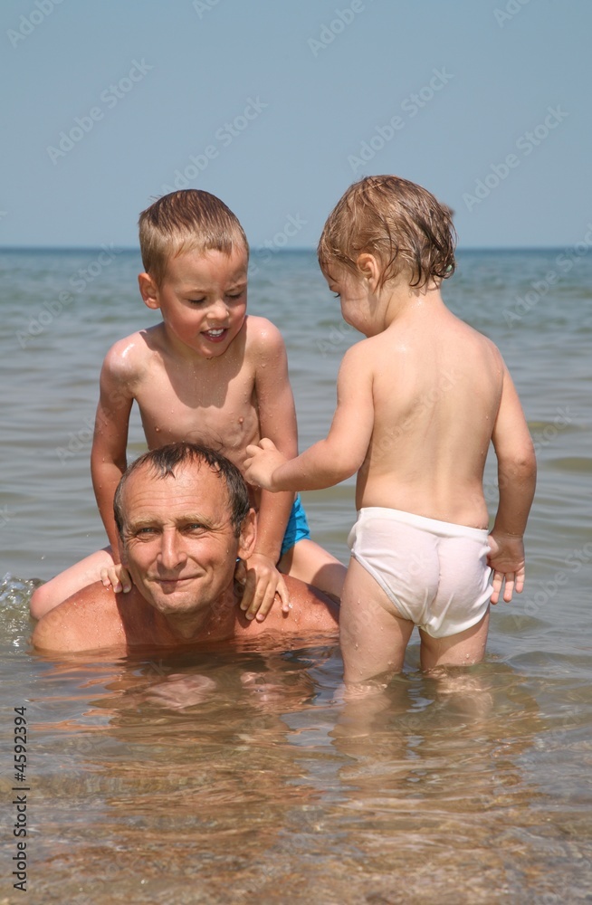 Grandfather with grandchildren on the sea Grandfather with grandchildren on the sea