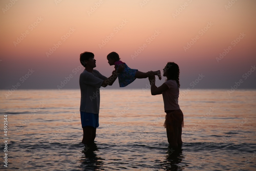 Fototapeta premium Family in sea on sunset