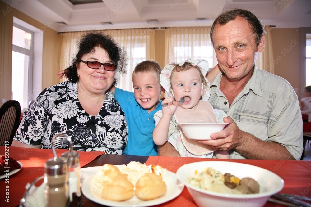 Grandmother with grandfather behind table with grandchildren