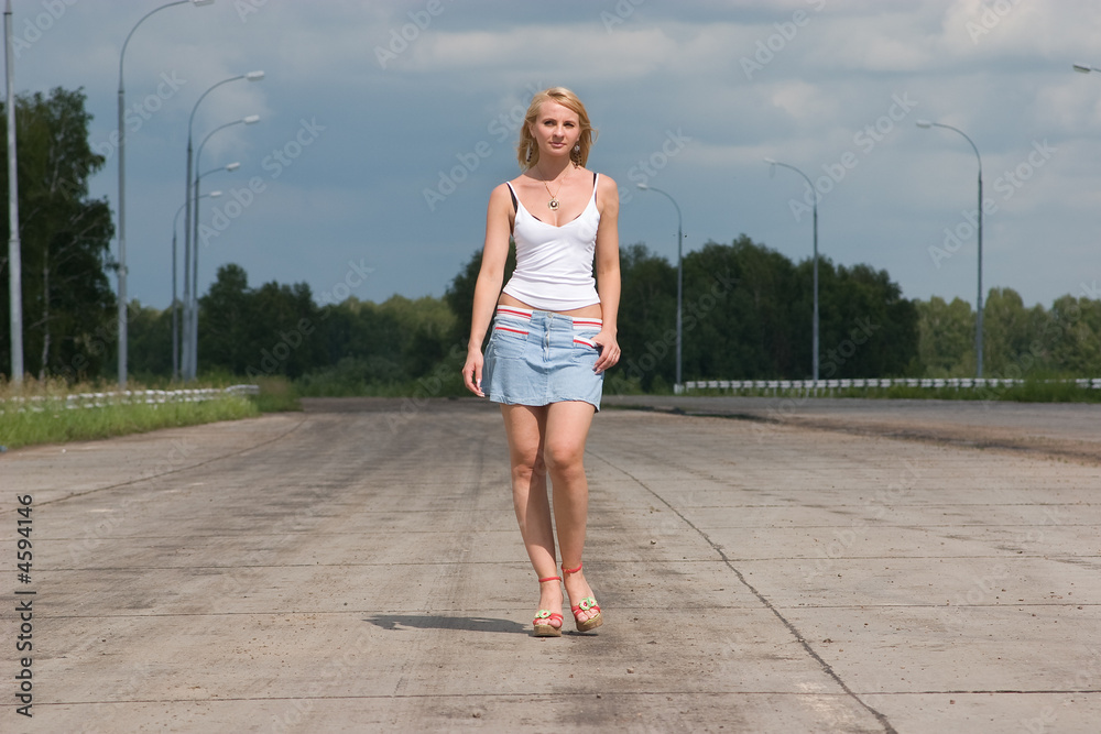 Young woman goes on a highway.