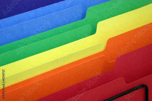 rainbow colored tabbed file folders in a basket