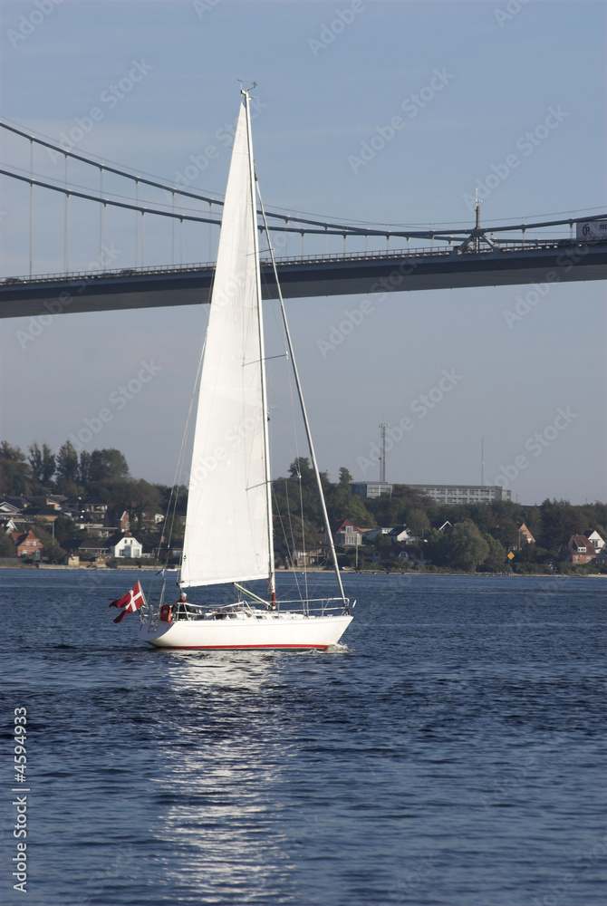 Danish sailboat sailing under suspension bridge 