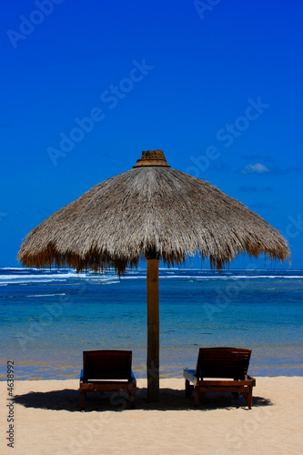 Fototapeta Naklejka Na Ścianę i Meble -  Two beach chairs under awning near ocean
