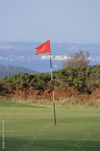 Golf flag or pin with distant sea views