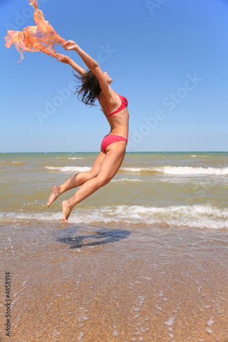 Fotografie woman jumping on the beach