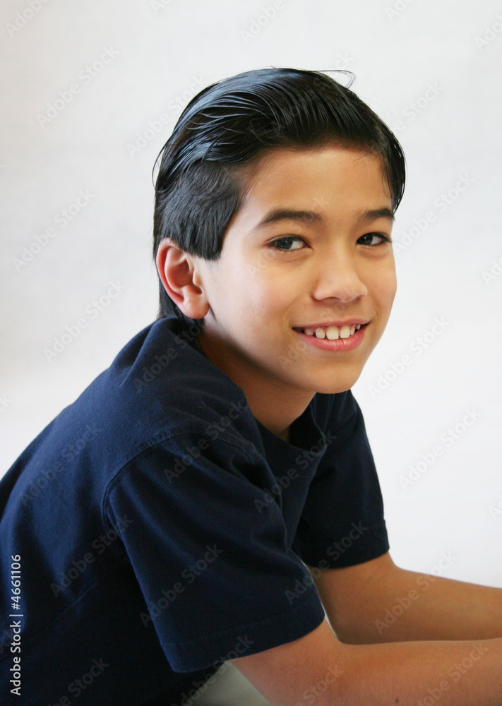Handsome young boy lying down looking towards camera Handsome young boy lying down looking towards camera