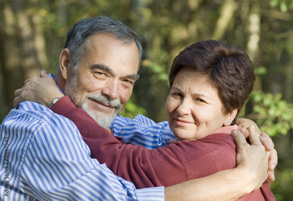 Happy elderly couple embracing outdoors Happy elderly couple embracing outdoors