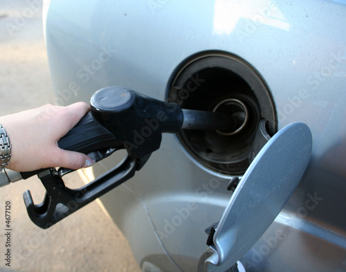 woman filling up auto tank at gas station