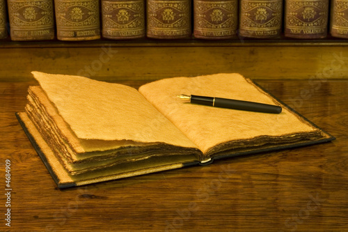 Open old diary or notebook with classic pen.