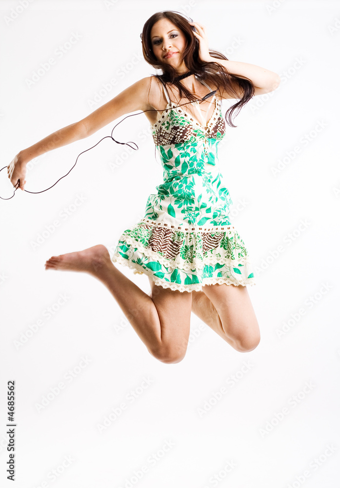 Naklejka premium Young female jumping while listening to music