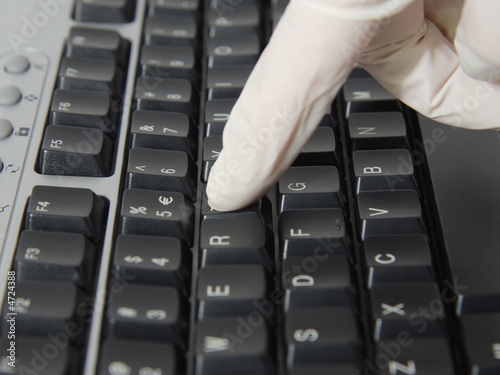 Invection control, woman in the latex gloves typing photo
