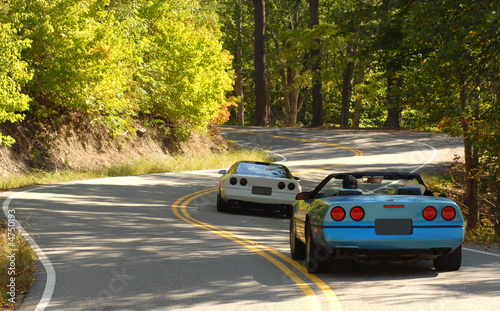 Two sports cars driving on a winding road photo
