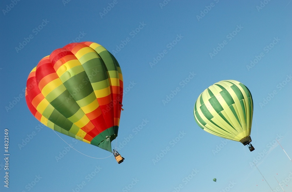 Obraz premium Two colorful hot air balloons against blue sky