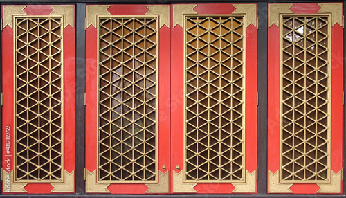 Traditional Chinese red wooden windows with golden grids.