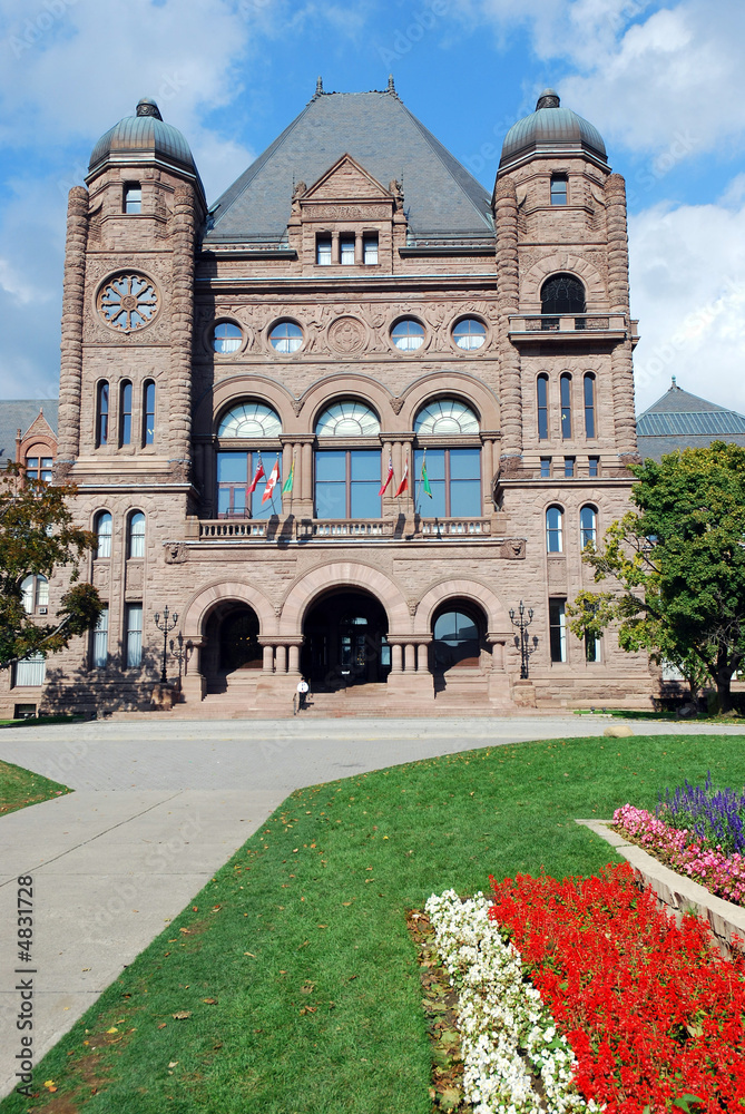 Ontario parliament building with red and white flowers