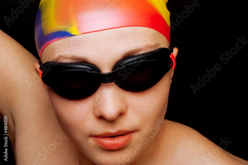 Young female swimmer against the black