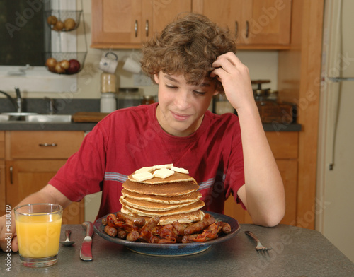boy looking at enormous pile of pancakes