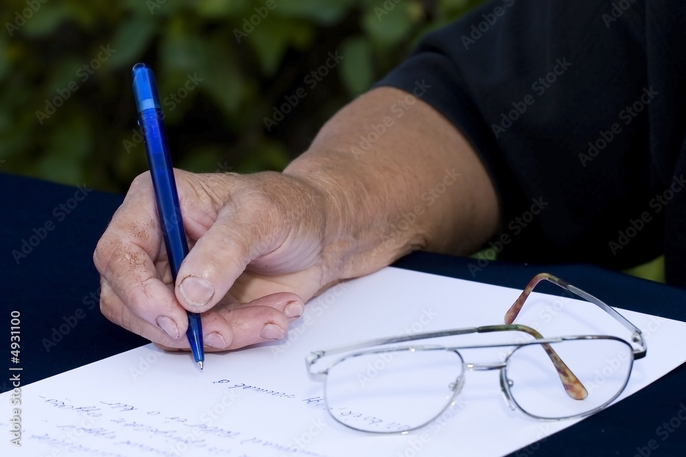 Naklejka premium Woman's hand holding a pen writing