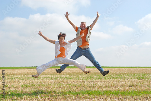 couple sautant dans les champs