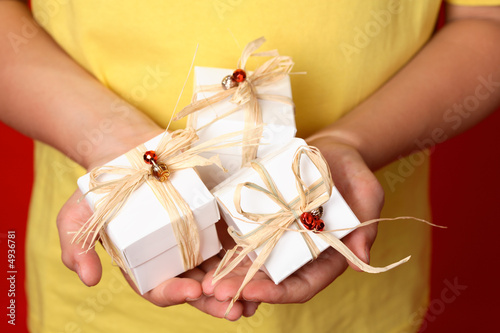 Little hands holding little Christmas or birthday gifts photo