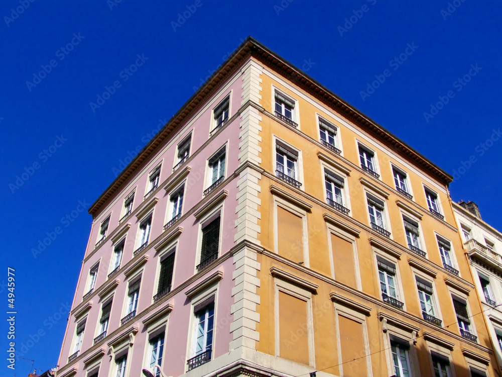 Immeuble en coin, deux couleurs: rose et jaune. Lyon.