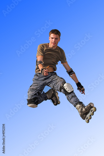 Roller boy jumping from parapet on the blue sky