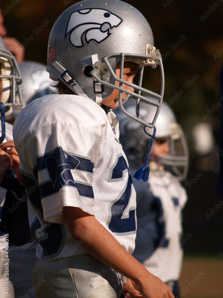 Fototapeta premium Football player on sideline wearing helmet