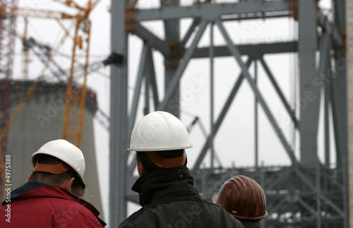 Drei Bauarbeiter mit Helm auf Großbaustelle photo