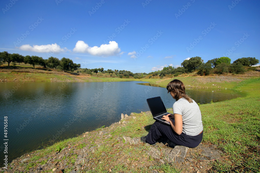 Girl working in portable pc in the country