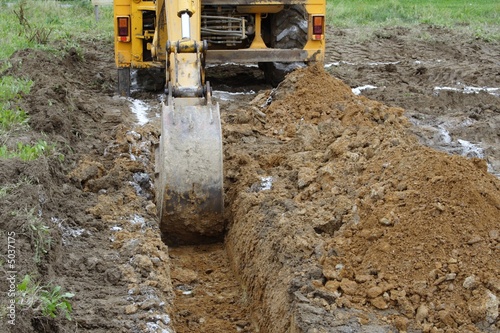 yellow building bulldozer scooping dirt photo