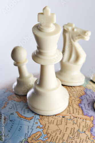 Chess pieces on an earth globe 