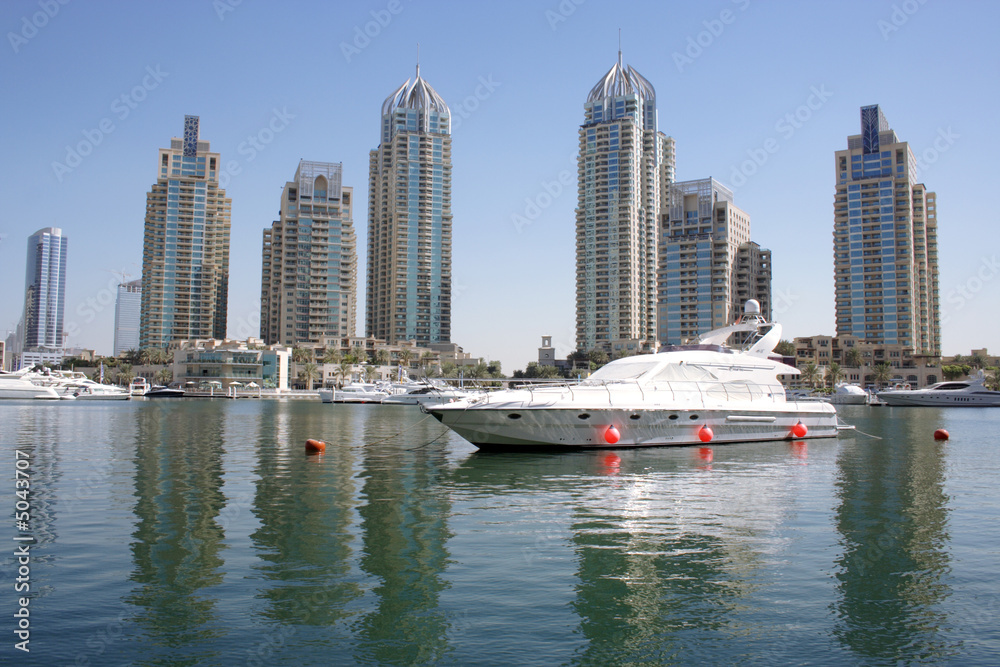 Fototapeta premium yatch in front of Dubai Marina buildings, united arab emirates