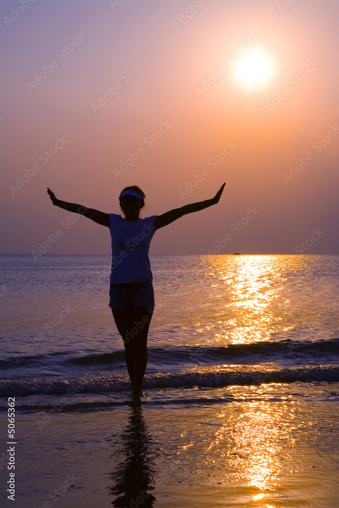 Girl walking along the coastline in sunset 2  