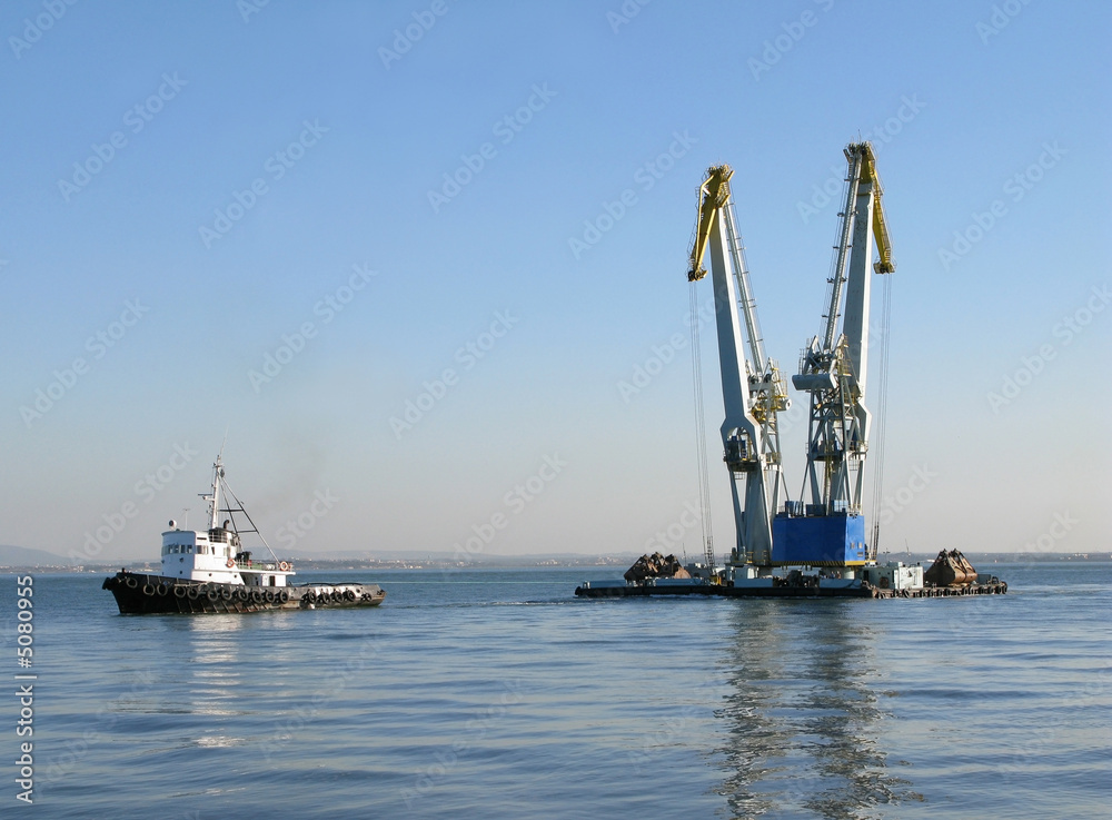 Large maritime cranes towed by boat Large maritime cranes towed by boat