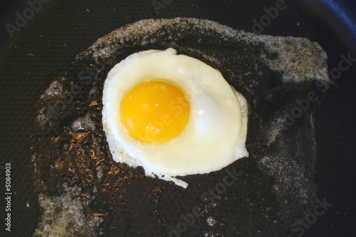 Sunnyside up egg frying in a pan