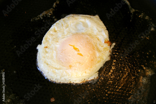 Over easy egg frying in a pan
