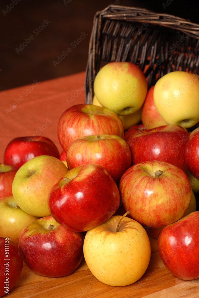 Apples falling out of a woven basket