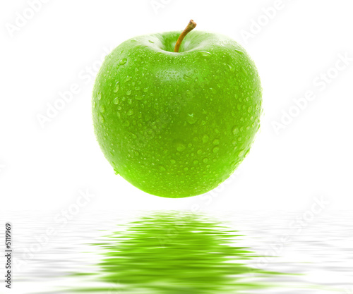 Wet juicy green apple over water. Isolated.