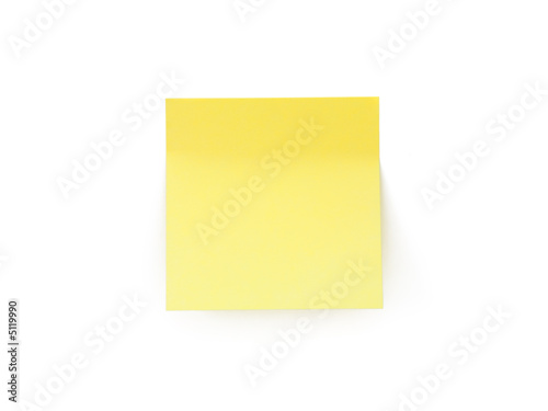 Yellow stick note on white wall. Isolated on white.