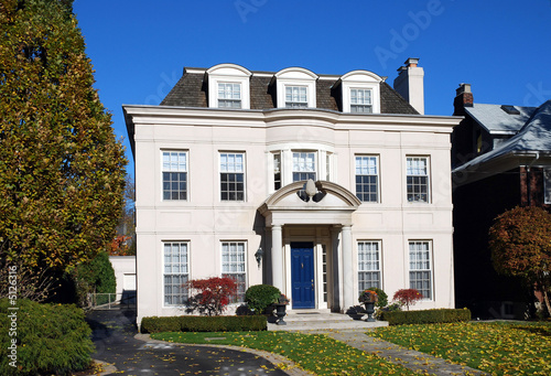 large stucco house with dormers and blue door © Spiroview Inc.