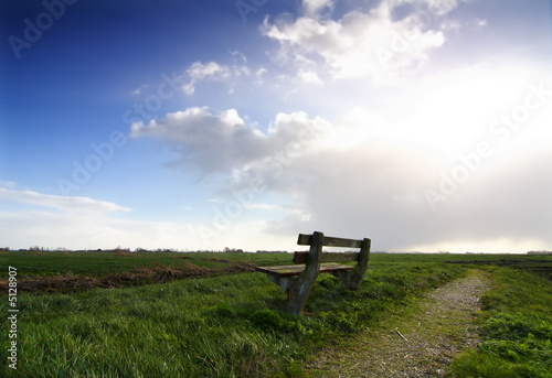 empty wooden bench in rural landscape