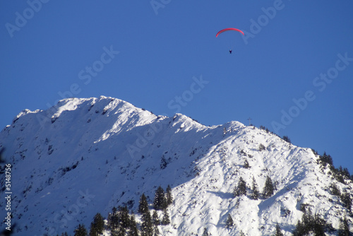 Paragliding über schneebedeckten Gipfeln der Allgäuer Alpen im Winter
