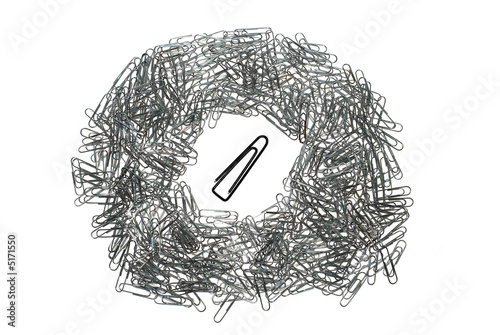 big isolated macro paper clip surrounded by many little