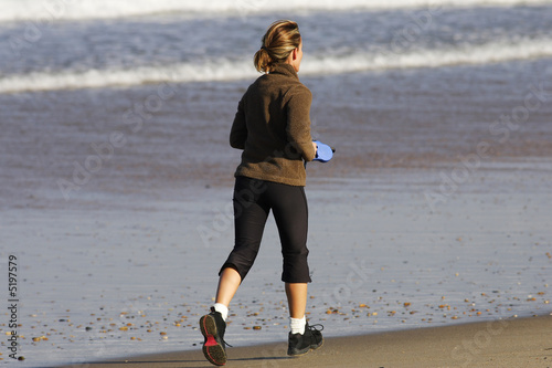 femme blonde entrain de courir sur la plage