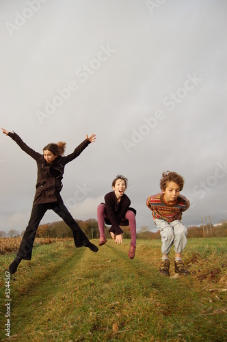 3 enfants sautant sur un chemin